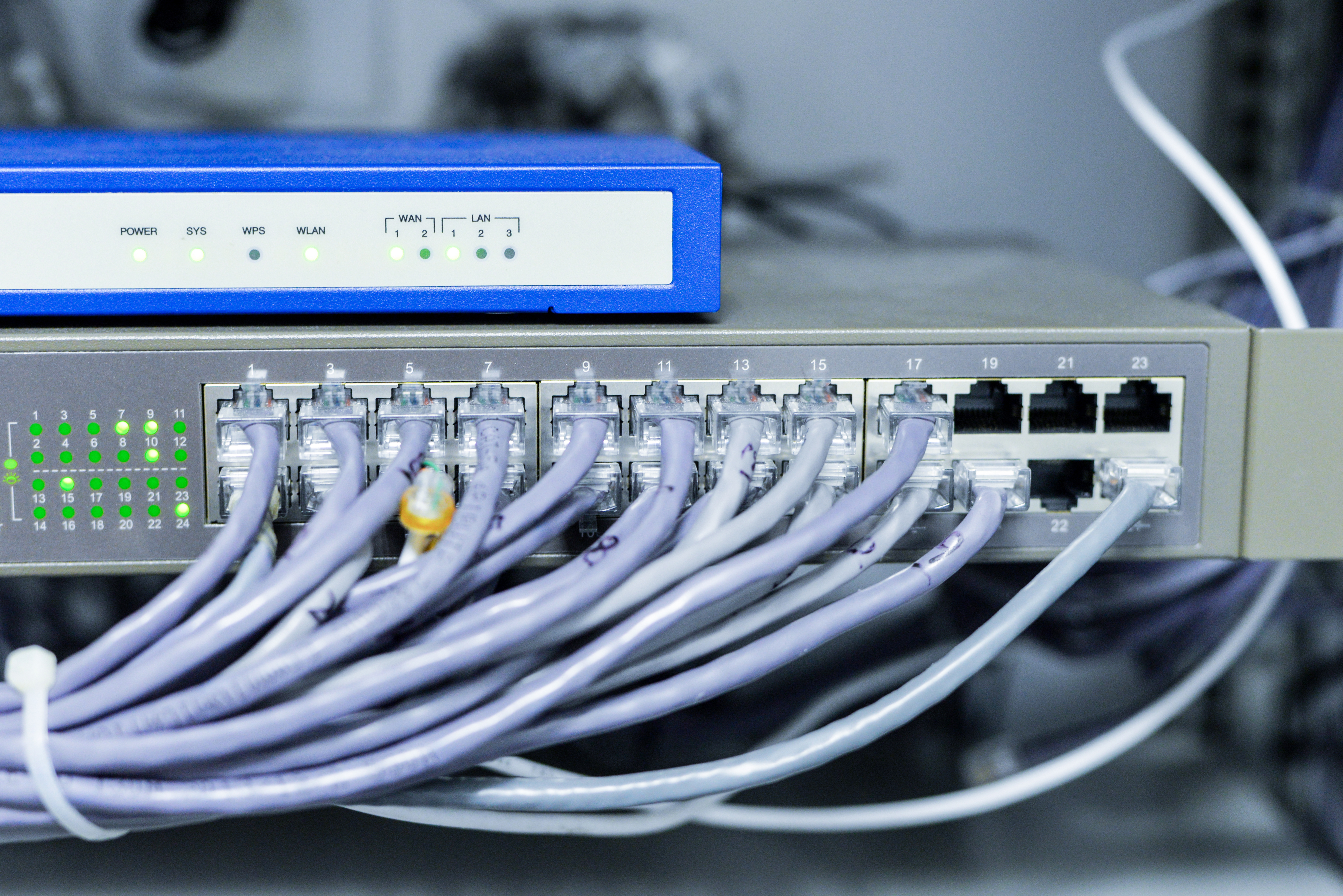 Network switch connected with multiple Ethernet cables, illustrating Mikrotik router setup process (cara setting MikroTik).