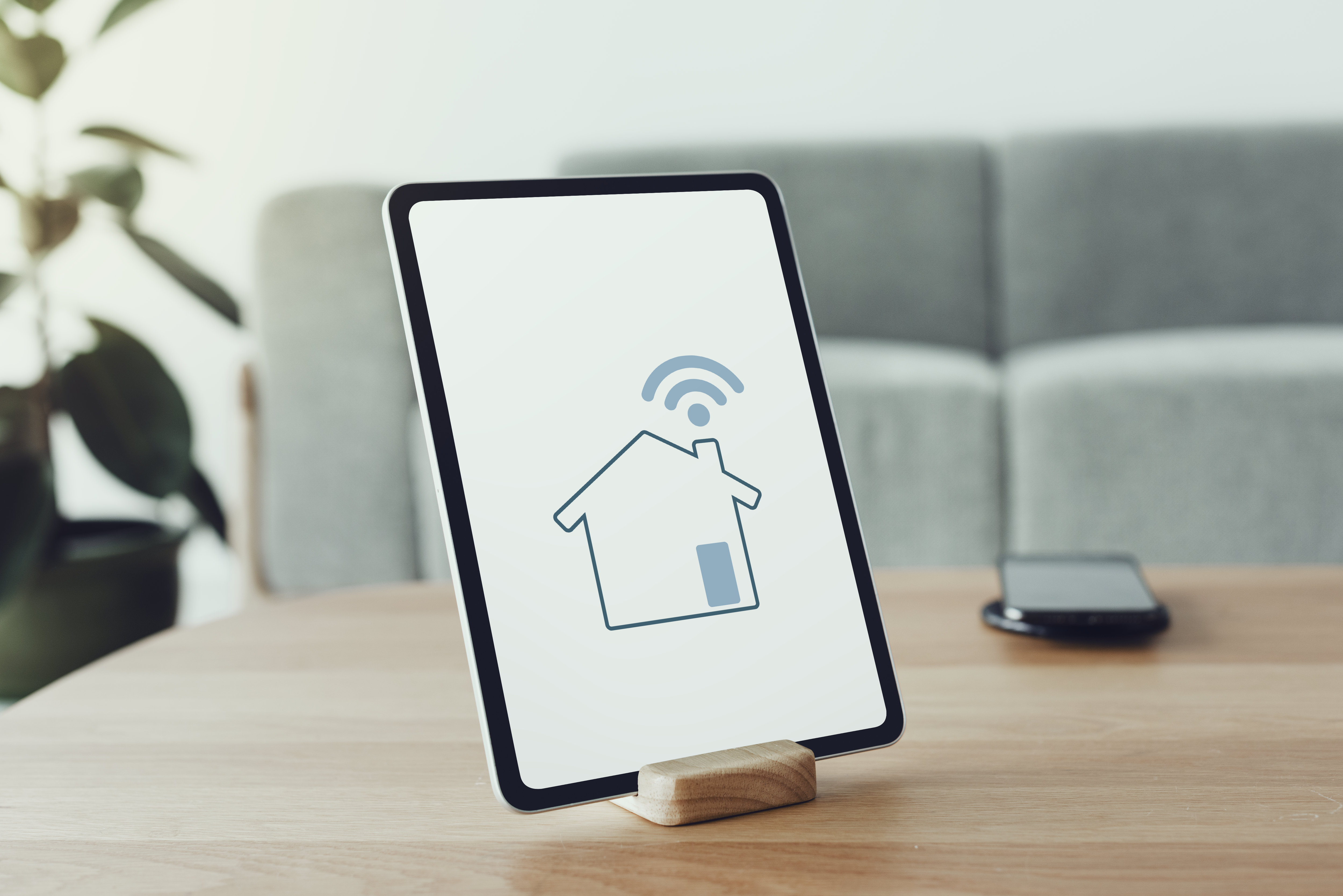 Digital tablet displaying a smart home controller interface on a wooden table, symbolizing fast and stable WiFi connection in Medan (WiFi di Medan).