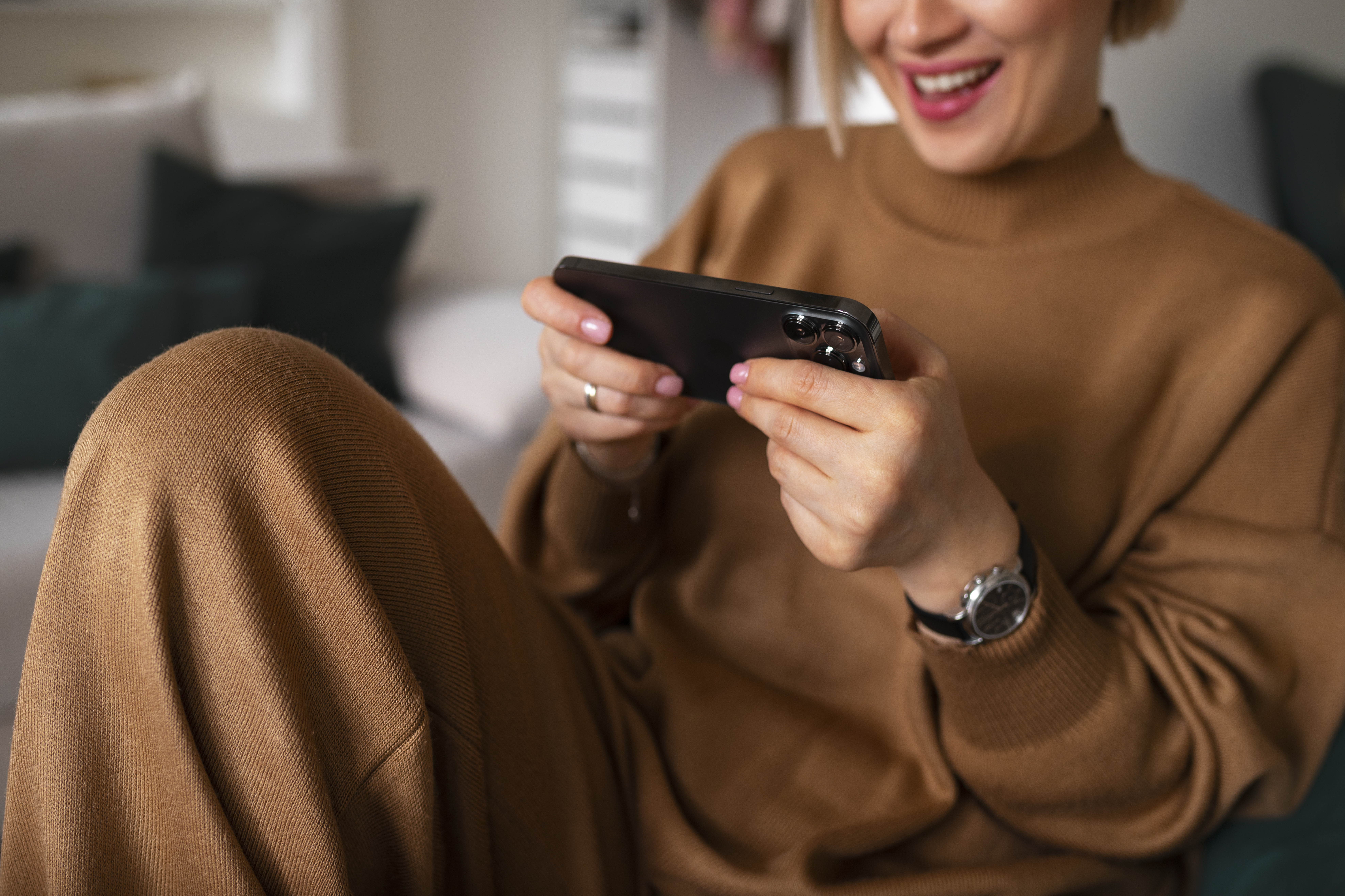 High-angle view of a woman playing a mobile game on her phone, illustrating offline Android gaming (game offline Android).