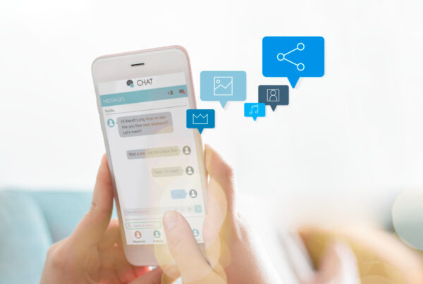 Close-up of a woman’s hands holding a smartphone while typing a message on a chat application.