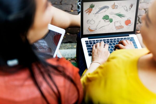 Woman and young girl using a laptop together, illustrating the Shopify vs WordPress comparison.