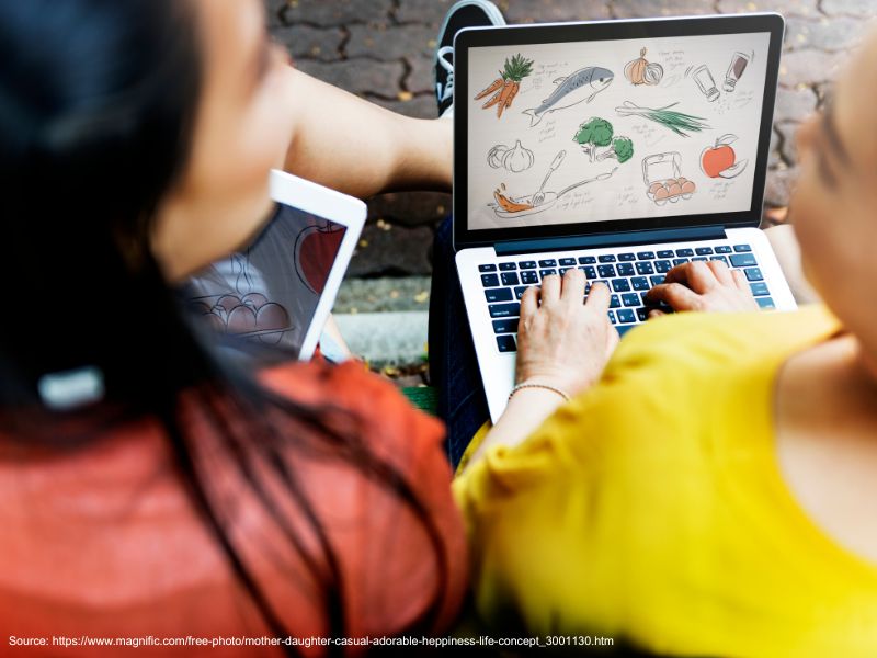 Woman and young girl using a laptop together, illustrating the Shopify vs WordPress comparison.